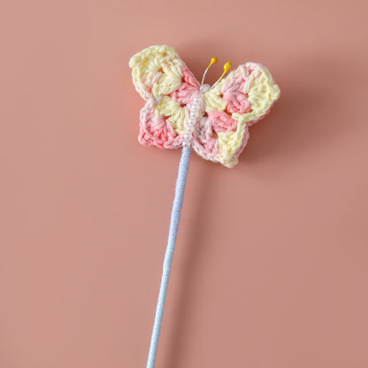 Crocheted butterfly flying flower branches