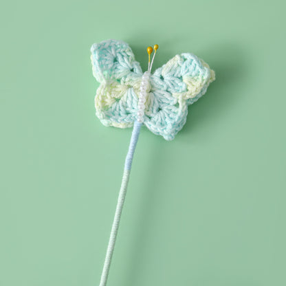 Crocheted butterfly flying flower branches