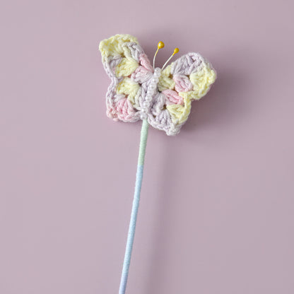 Crocheted butterfly flying flower branches